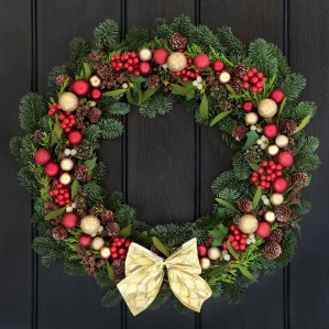 Christmas wreath with red and gold bauble decorations, bow, holl